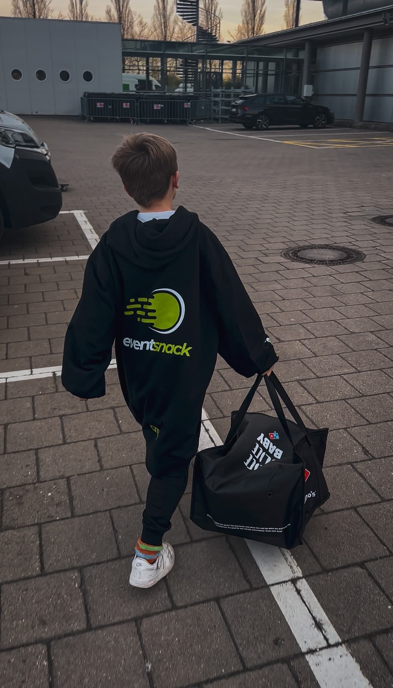 EventSnack-Runner mit Domino’s-Pizzabag auf dem Weg zur CAGGTUS-Gaming-Fläche